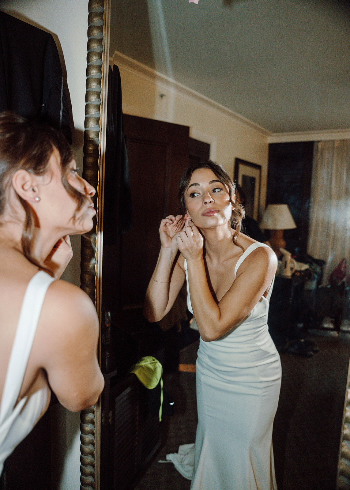 Bride putting on her earrings before the wedding ceremony