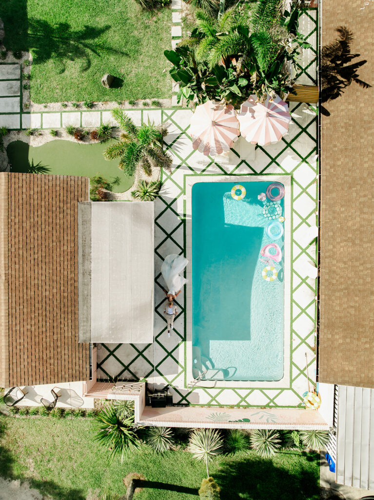 Aerial view of the wedding couple beside the pool